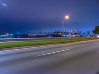 a blurry image of the highway in night time with lights reflecting off of the asphalt