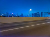 a blurry image of the highway in night time with lights reflecting off of the asphalt