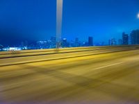 a blurry image of the highway in night time with lights reflecting off of the asphalt