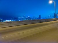 a blurry image of the highway in night time with lights reflecting off of the asphalt