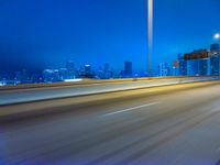 a blurry image of the highway in night time with lights reflecting off of the asphalt