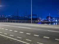 a road with a bridge across it near a large building at night time with traffic
