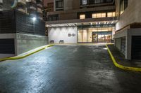 street corner in night with car and bicycle racket at entrance by side of building