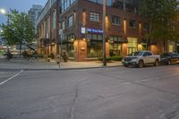 a car driving past a royal bank store at night on a city street lined with buildings