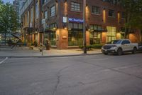 a car driving past a royal bank store at night on a city street lined with buildings