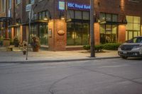 a car driving past a royal bank store at night on a city street lined with buildings