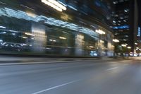 cars driving in the city in motion on a highway at night time, with buildings and traffic