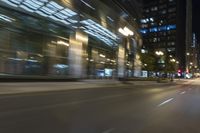 cars driving in the city in motion on a highway at night time, with buildings and traffic