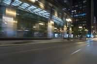 cars driving in the city in motion on a highway at night time, with buildings and traffic