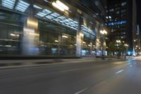 cars driving in the city in motion on a highway at night time, with buildings and traffic