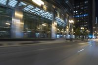 cars driving in the city in motion on a highway at night time, with buildings and traffic