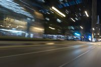 cars driving in the city in motion on a highway at night time, with buildings and traffic