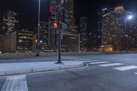 an empty city freeway at night with high rise buildings in the background with white and yellow lights