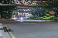 a city street with buildings and neon lights at night time in hong china as seen from an empty city highway