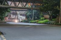 a city street with buildings and neon lights at night time in hong china as seen from an empty city highway