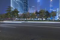an empty street in a city with high buildings in the background at night time time
