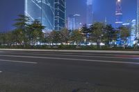 an empty street in a city with high buildings in the background at night time time