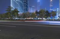 an empty street in a city with high buildings in the background at night time time