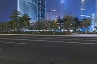 an empty street in a city with high buildings in the background at night time time