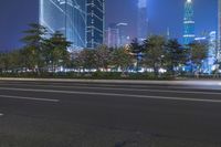 an empty street in a city with high buildings in the background at night time time