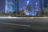 an empty street in a city with high buildings in the background at night time time