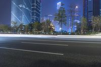 an empty street in a city with high buildings in the background at night time time