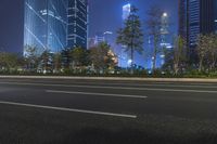 an empty street in a city with high buildings in the background at night time time