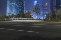 an empty street in a city with high buildings in the background at night time time