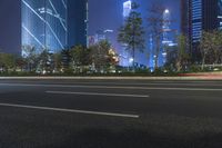 an empty street in a city with high buildings in the background at night time time