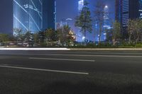 an empty street in a city with high buildings in the background at night time time