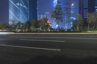 an empty street in a city with high buildings in the background at night time time