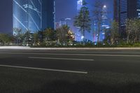 an empty street in a city with high buildings in the background at night time time