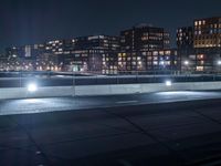 a view of a city from an overpass at night with lots of windows and lights