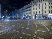 the view of an intersection in the city at night, including cars moving down the road