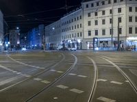 the view of an intersection in the city at night, including cars moving down the road