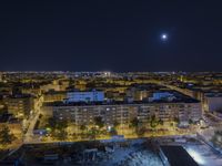 the town lights shine bright in this nighttime scene of madrid, with buses and cars on it