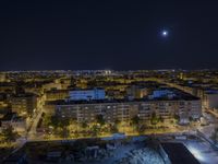 the town lights shine bright in this nighttime scene of madrid, with buses and cars on it