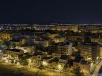 the town lights shine bright in this nighttime scene of madrid, with buses and cars on it