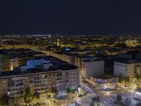 the town lights shine bright in this nighttime scene of madrid, with buses and cars on it