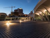 modern architecture in the middle of a city with a bridge over a river near it