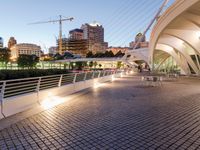 modern architecture in the middle of a city with a bridge over a river near it