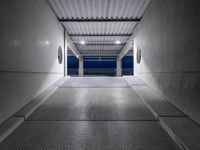 a walkway under construction with metal grates and door open onto the ocean shore at dusk