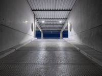 a walkway under construction with metal grates and door open onto the ocean shore at dusk