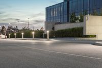 a person riding an atv past a street light pole on the road at night in front of buildings