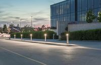 a person riding an atv past a street light pole on the road at night in front of buildings