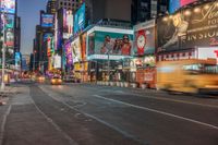 a busy city at night time with the motion bluring of the taxi and billboards