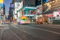 a busy city at night time with the motion bluring of the taxi and billboards