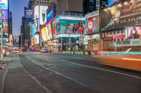 a busy city at night time with the motion bluring of the taxi and billboards