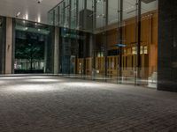 an open door at the lobby of a modern building with glass doors on either side