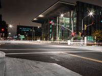 traffic lights and buildings are lit up at night time in the city square area of this area